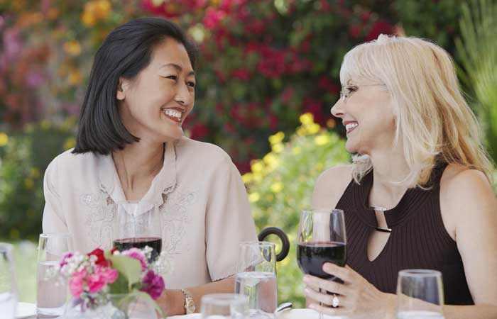 Two Women with wine smiling at each other