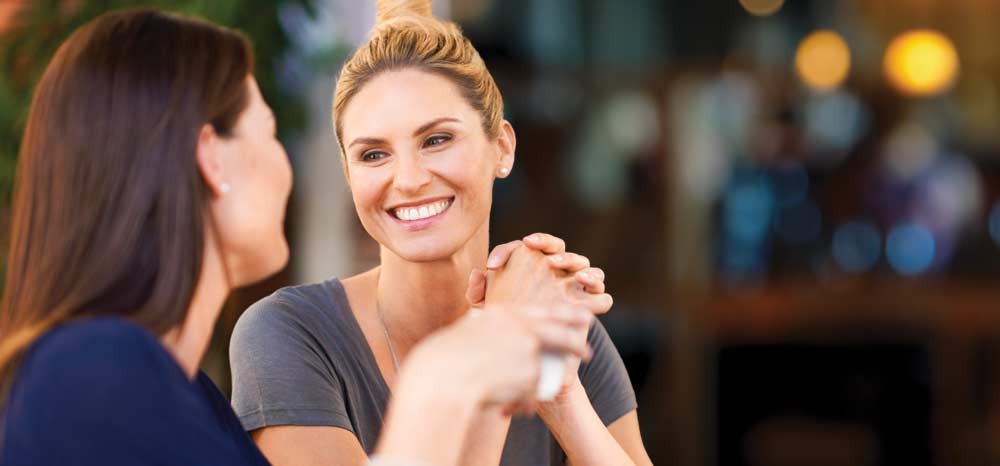 Woman smiling and talking to another woman